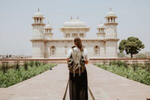 Jeune fille avec son sac de randonnée devant un monument